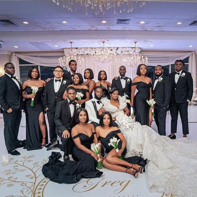 Wedding party with bride in white and guests in formal all-black attire.