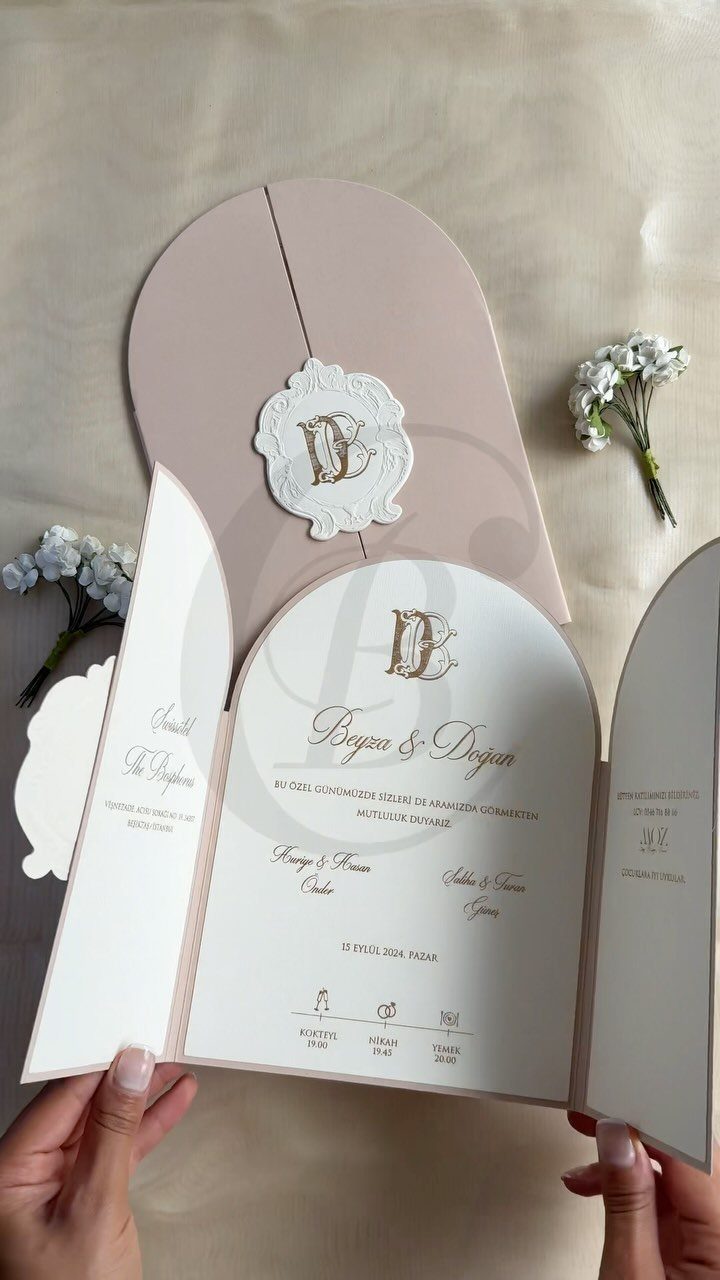 Arched pale pink and white wedding invitation suite with gold calligraphy and wax seal.