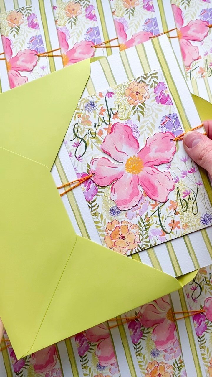 Floral wedding invitation with pink watercolor flowers and a lime green envelope.