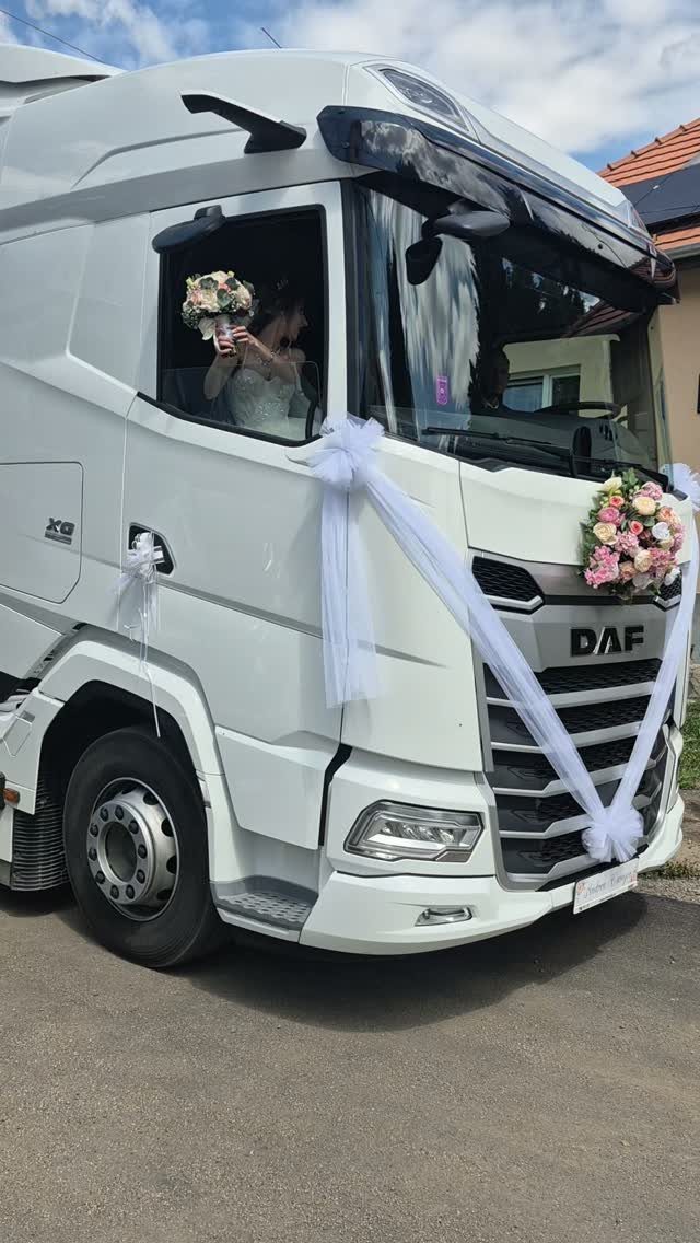 White decorated semi-truck with a bride looking out the window for wedding transport