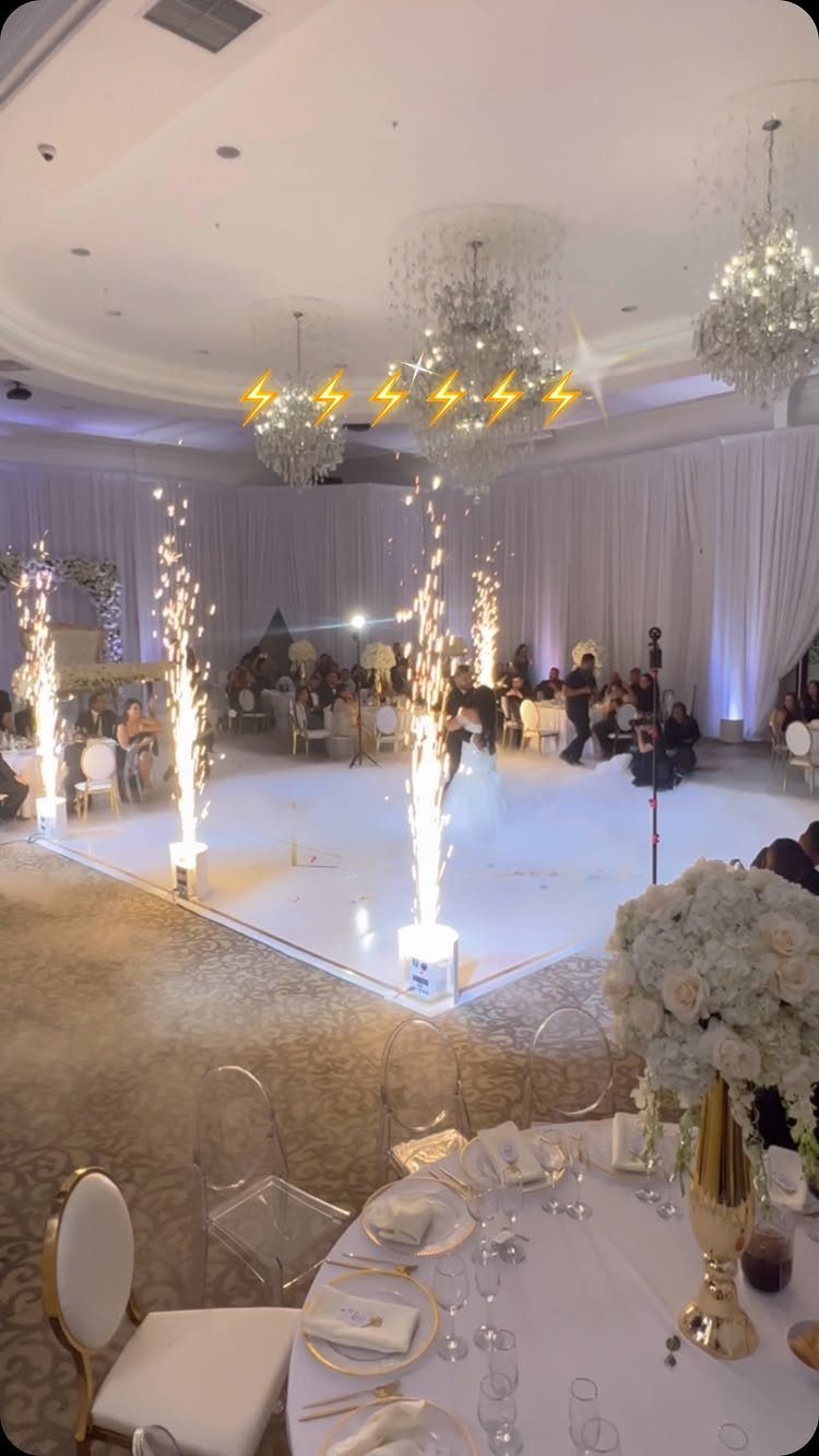 Couple dancing on an illuminated wedding dance floor surrounded by indoor sparklers