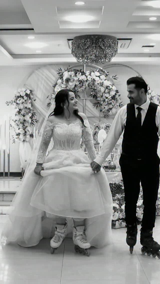Bride and groom wearing roller skates holding hands in a decorated wedding venue.