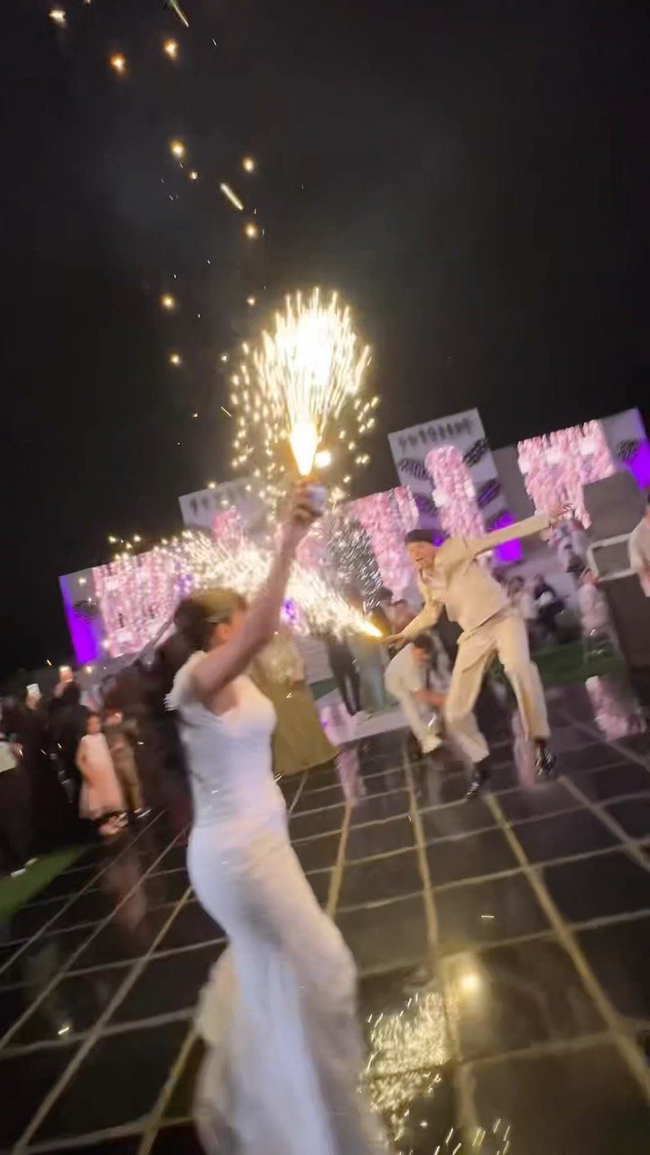 Bride and groom dancing with sparklers on a reflective wedding dance floor