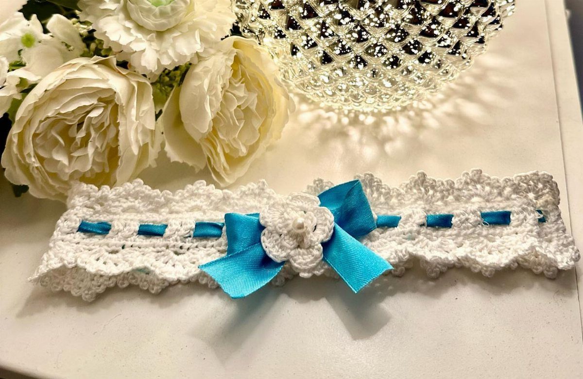 White crochet lace garter with a blue satin bow and crochet flower.