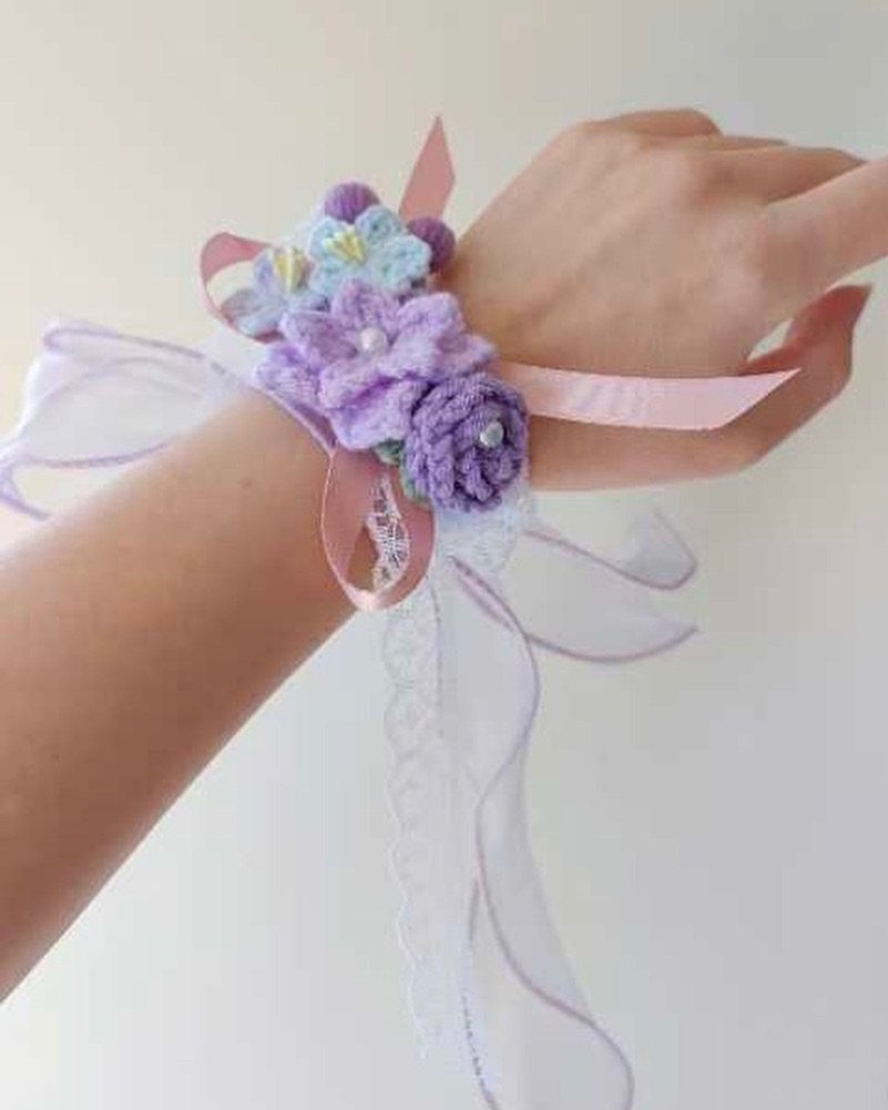 Crochet floral bracelet with purple flowers and white lace on a wrist