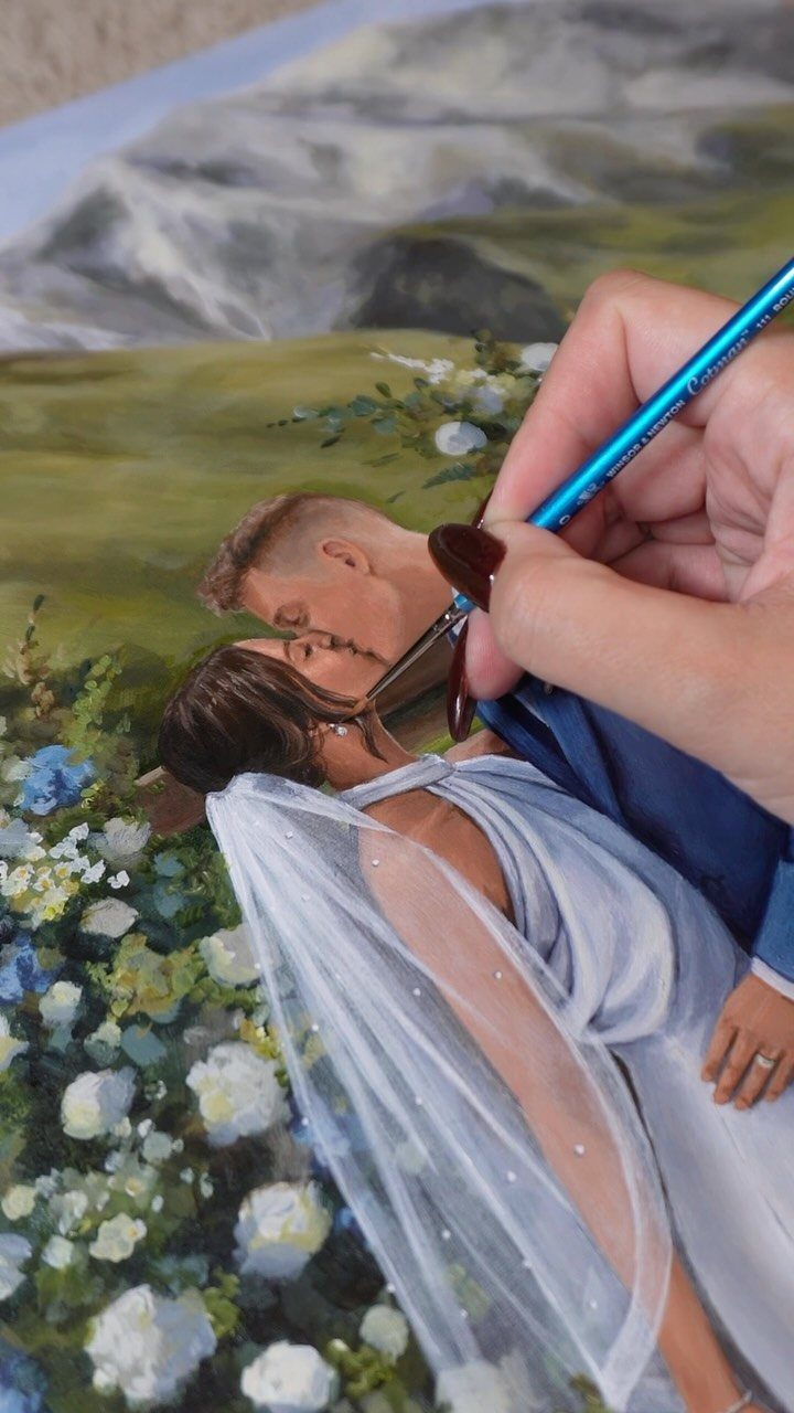 Hand painting a romantic wedding couple kissing on a canvas with a paintbrush