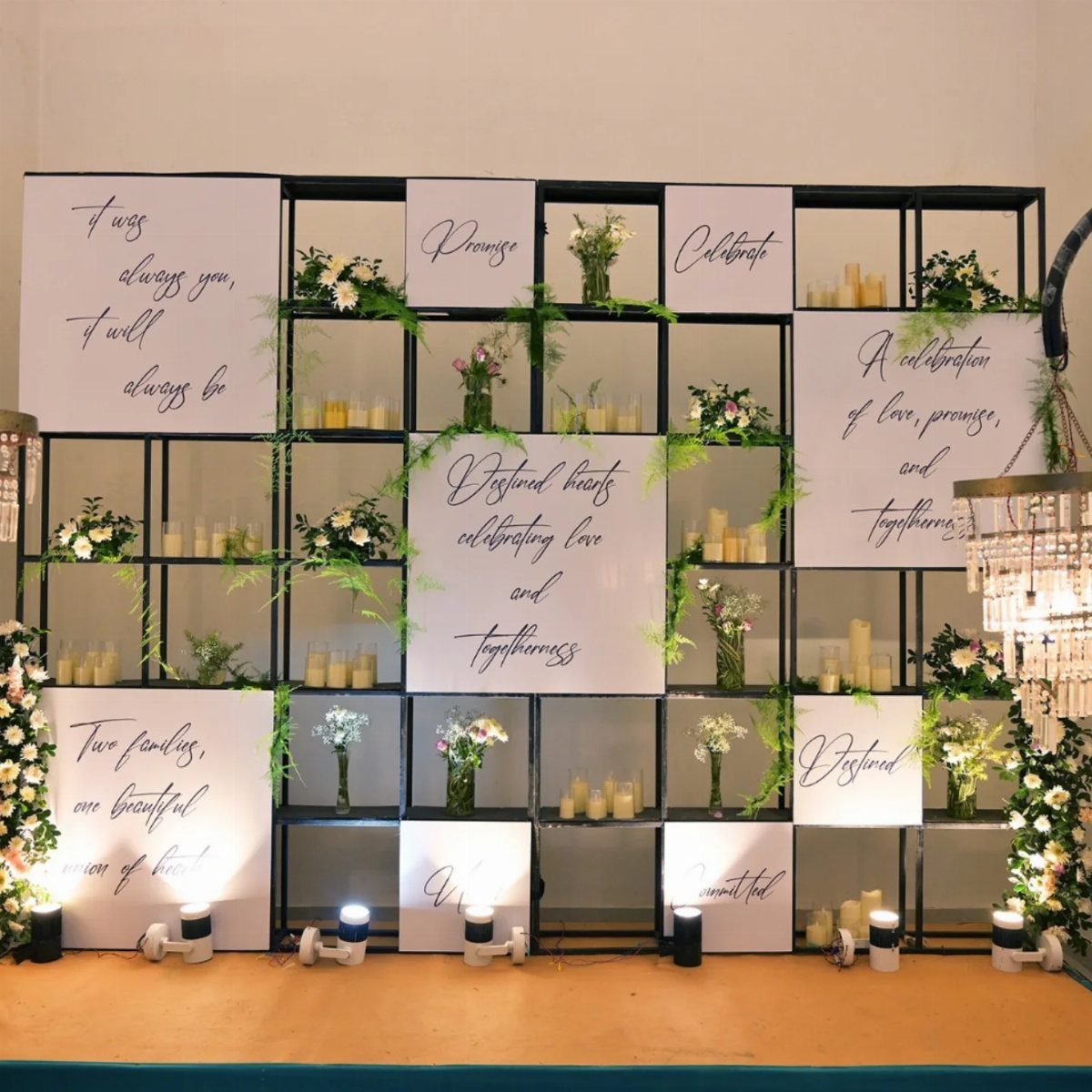 Black grid backdrop with romantic text panels, white flowers, and glowing candles.