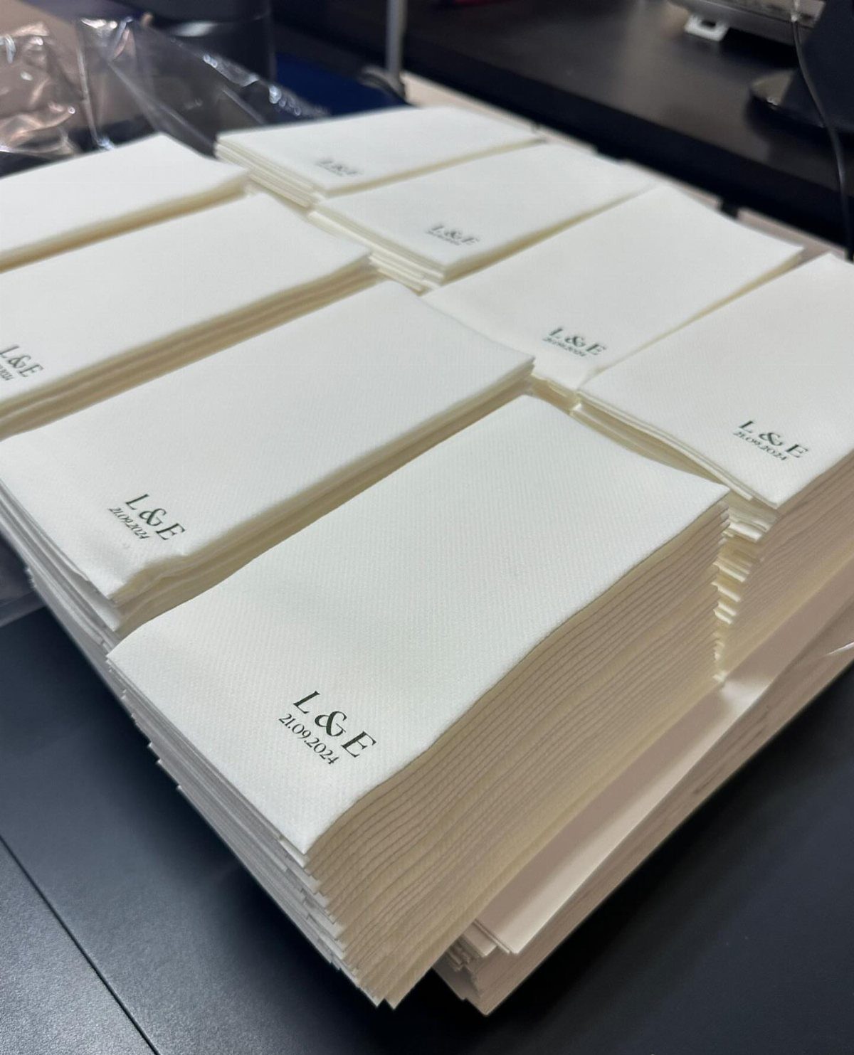 Stacks of white napkins printed with a black monogram and wedding date.
