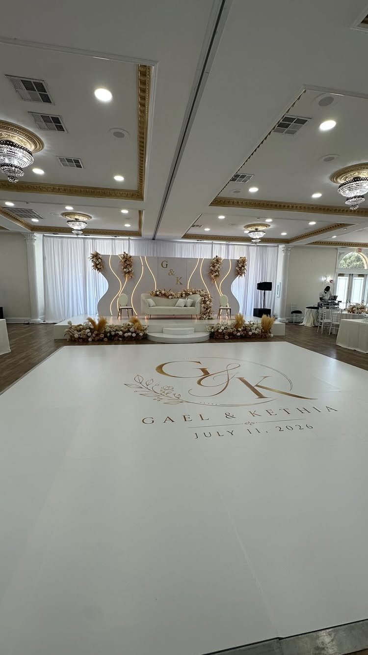 White wedding dance floor with gold monogram in a decorated ballroom setting