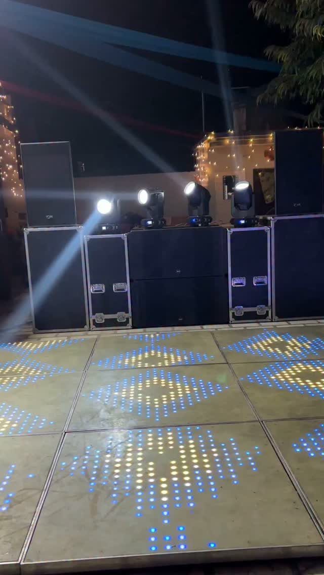 LED dance floor and stage lights with beams casting upward at a party.