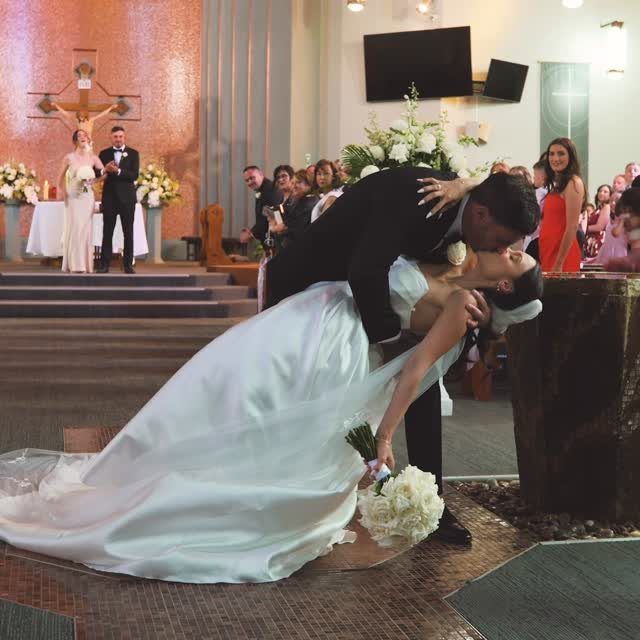Groom dipping bride for a kiss during a wedding ceremony in a church