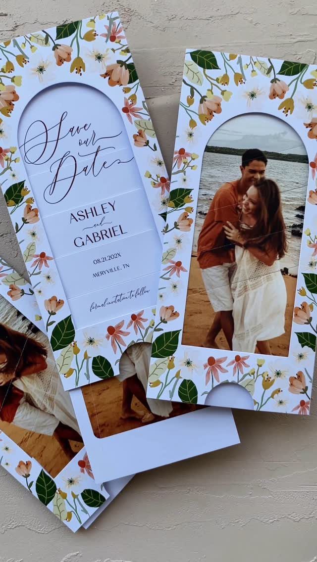 Floral save-the-date cards featuring a couple on a beach and elegant script text.