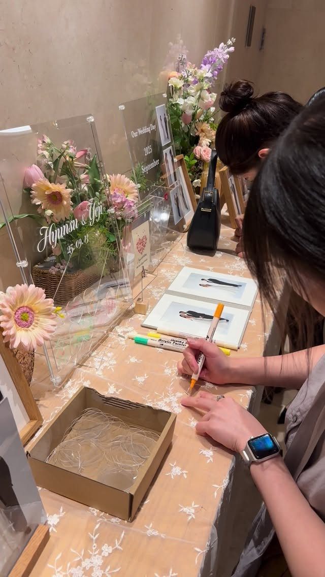 Guest book with photos on a decorated table being signed by a guest.