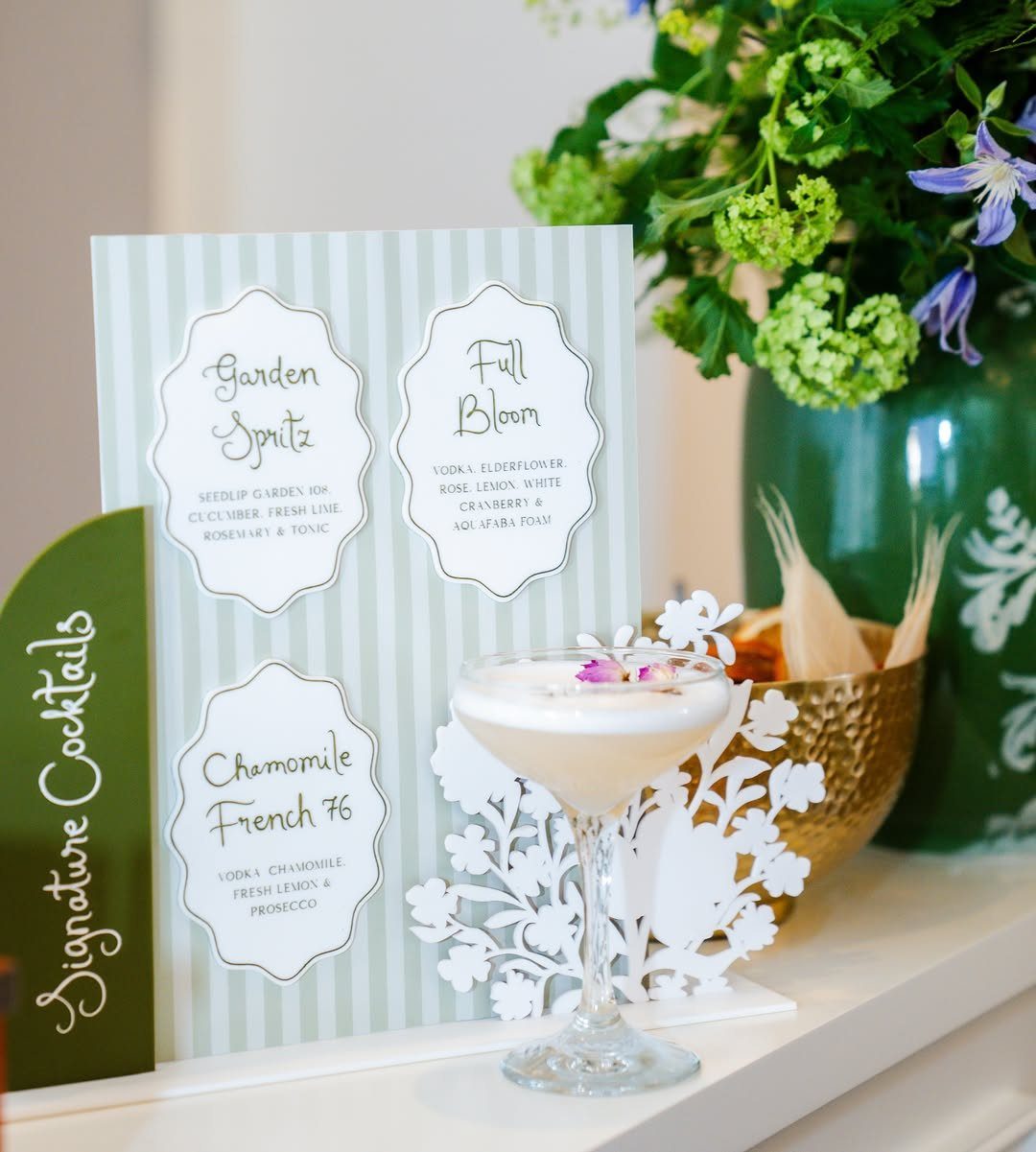 Creamy signature cocktail next to a striped menu card with floral decorations