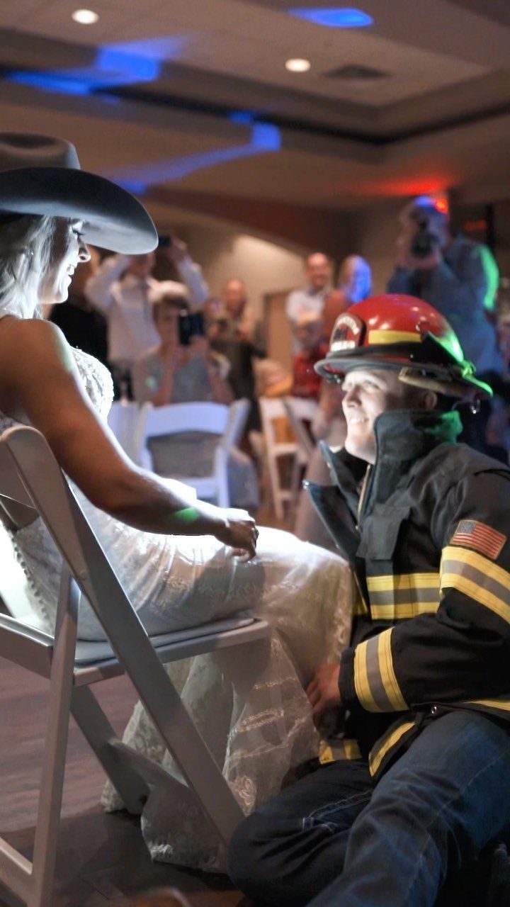 Bride in white dress and groom in firefighter gear during wedding reception