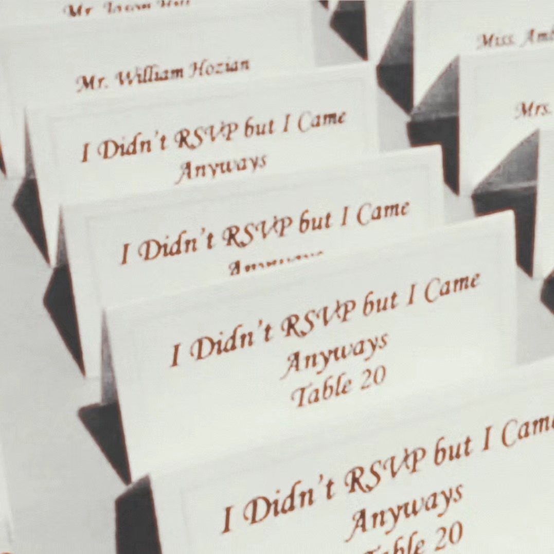White wedding place cards with humorous text about not RSVPing and table numbers.