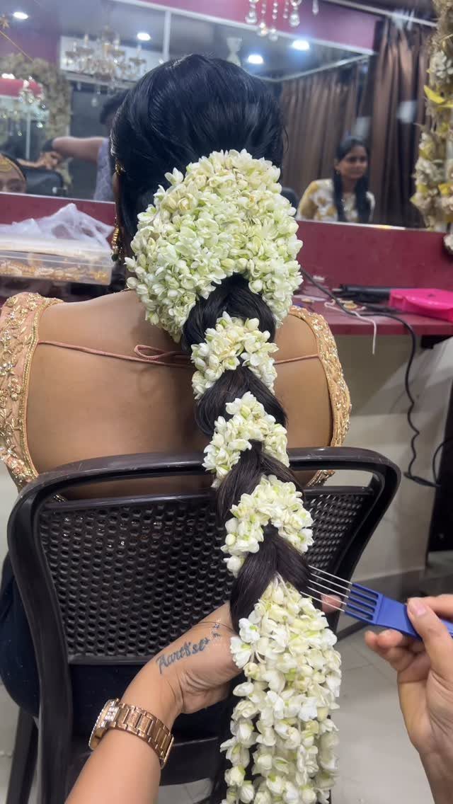 Long dark braid decorated with white jasmine flowers on a woman's head