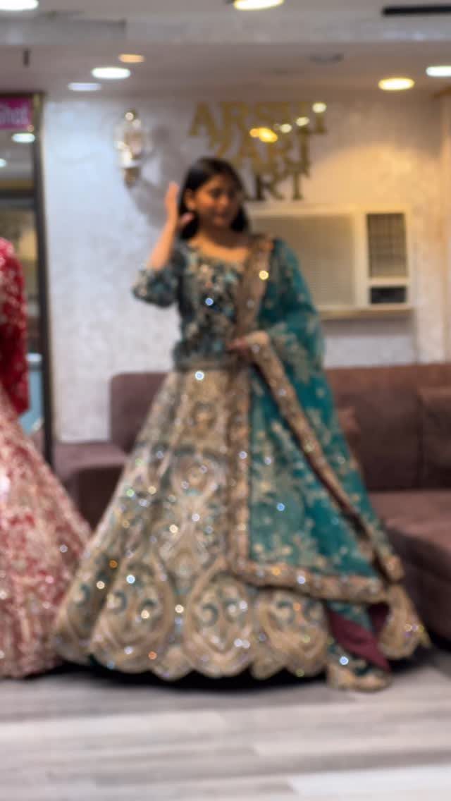 Woman wearing a teal and gold embroidered lehenga choli with a matching dupatta.