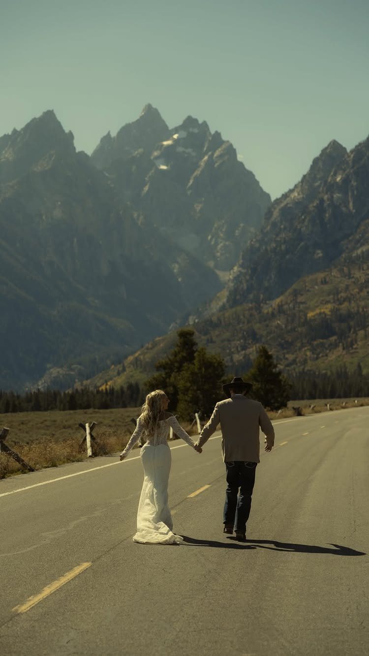 Wedding couple walking down a road with Grand Teton mountains in the background