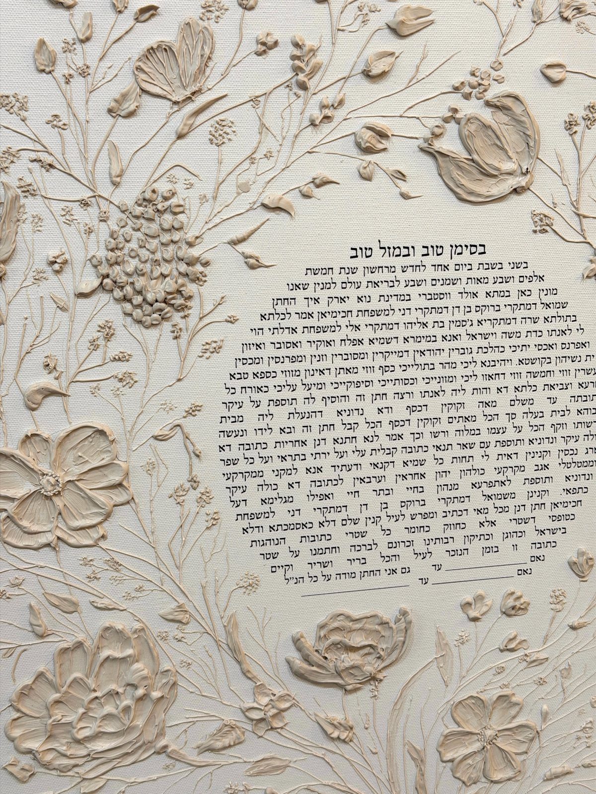 Ketubah marriage contract with Hebrew text surrounded by cream-colored 3D floral relief carvings.