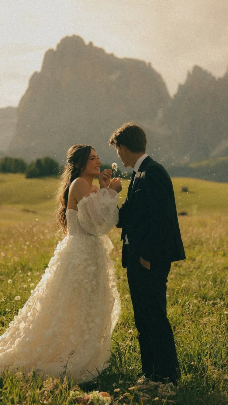 Bride and groom standing in a mountain meadow with a warm filmic edit.