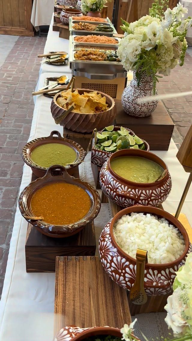 Mexican buffet spread with clay pots of salsa, rice, and tortilla chips.