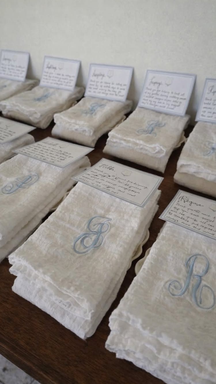 White linen towels with blue embroidered monograms and personalized handwritten gift cards.