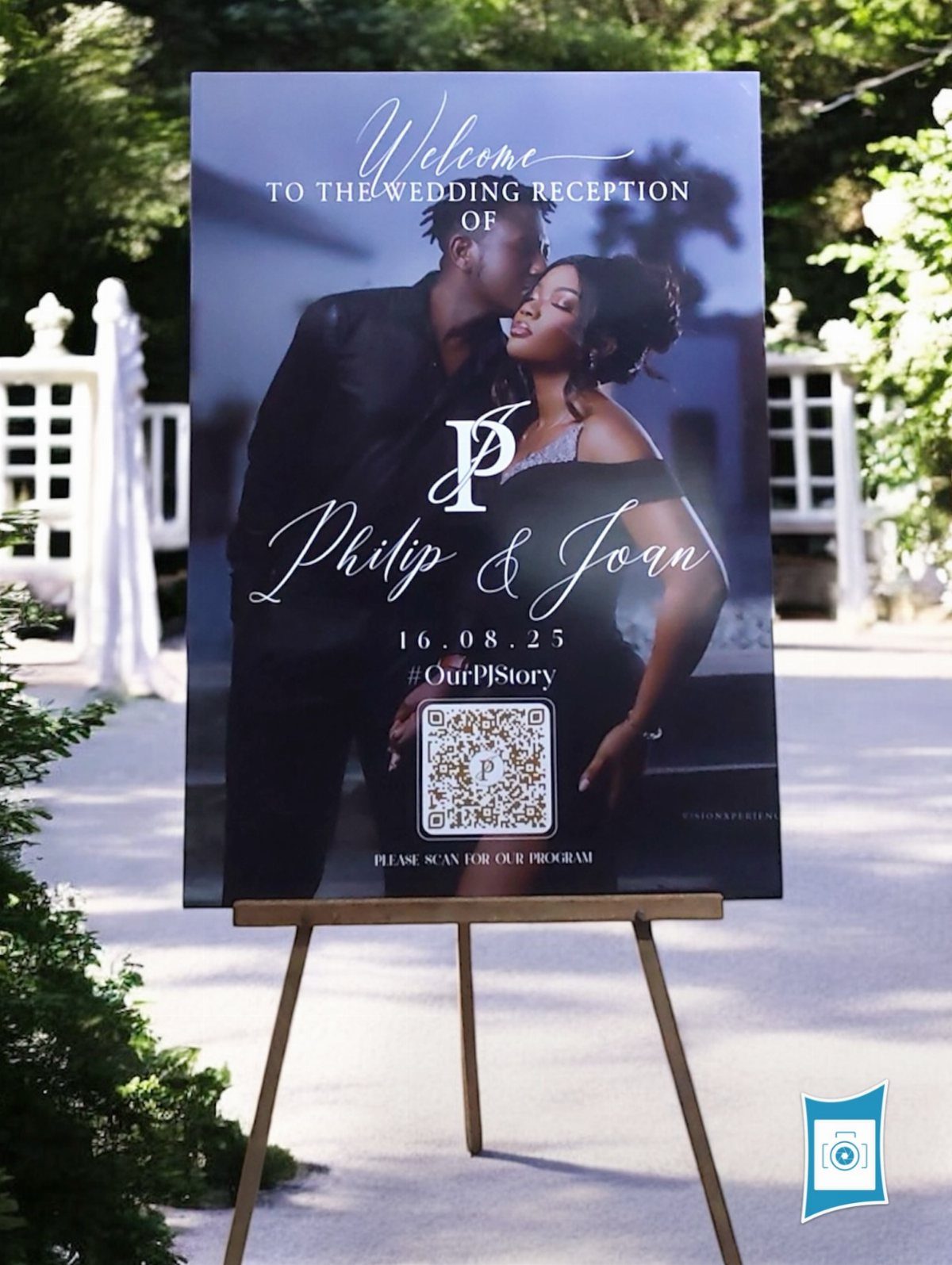 Wedding welcome sign on a wooden easel featuring a couple and a monogram.