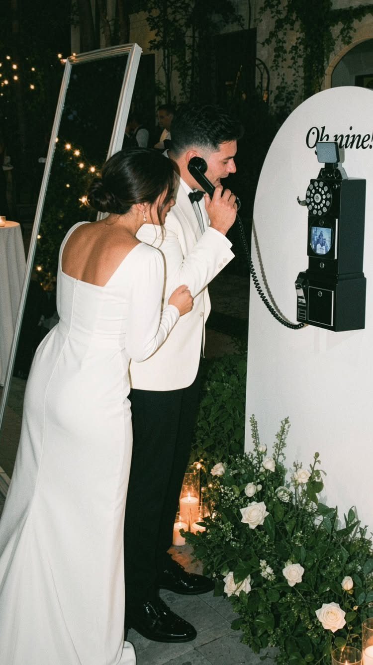 Bride and groom using a vintage black rotary phone for wedding guest messages.