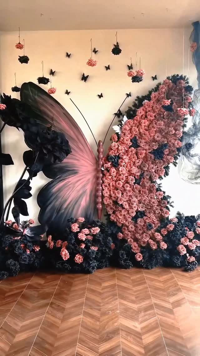 Butterfly wall installation made of pink and black roses on a wooden floor