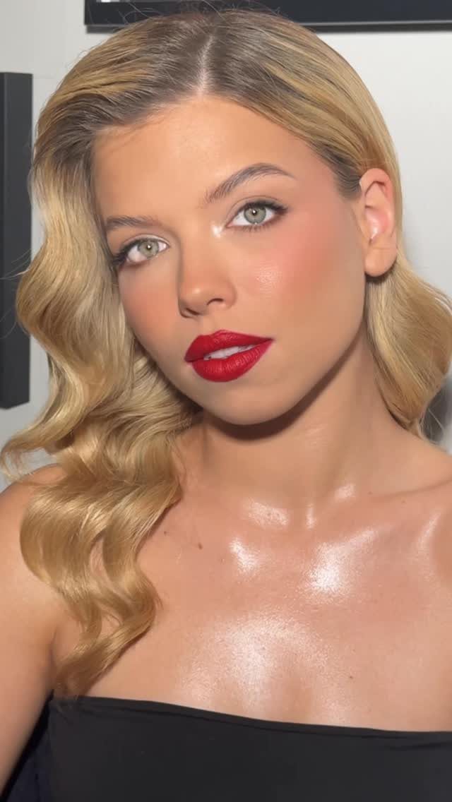 Woman with blonde retro waves and classic red lipstick posing for a portrait.