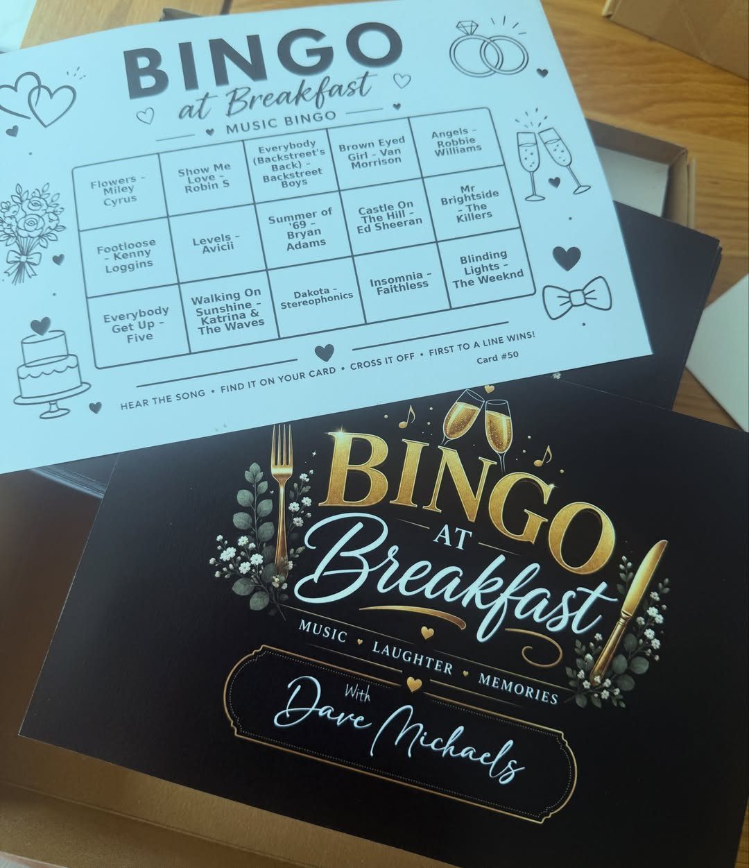 Music bingo card and matching black invitation for a wedding breakfast event.