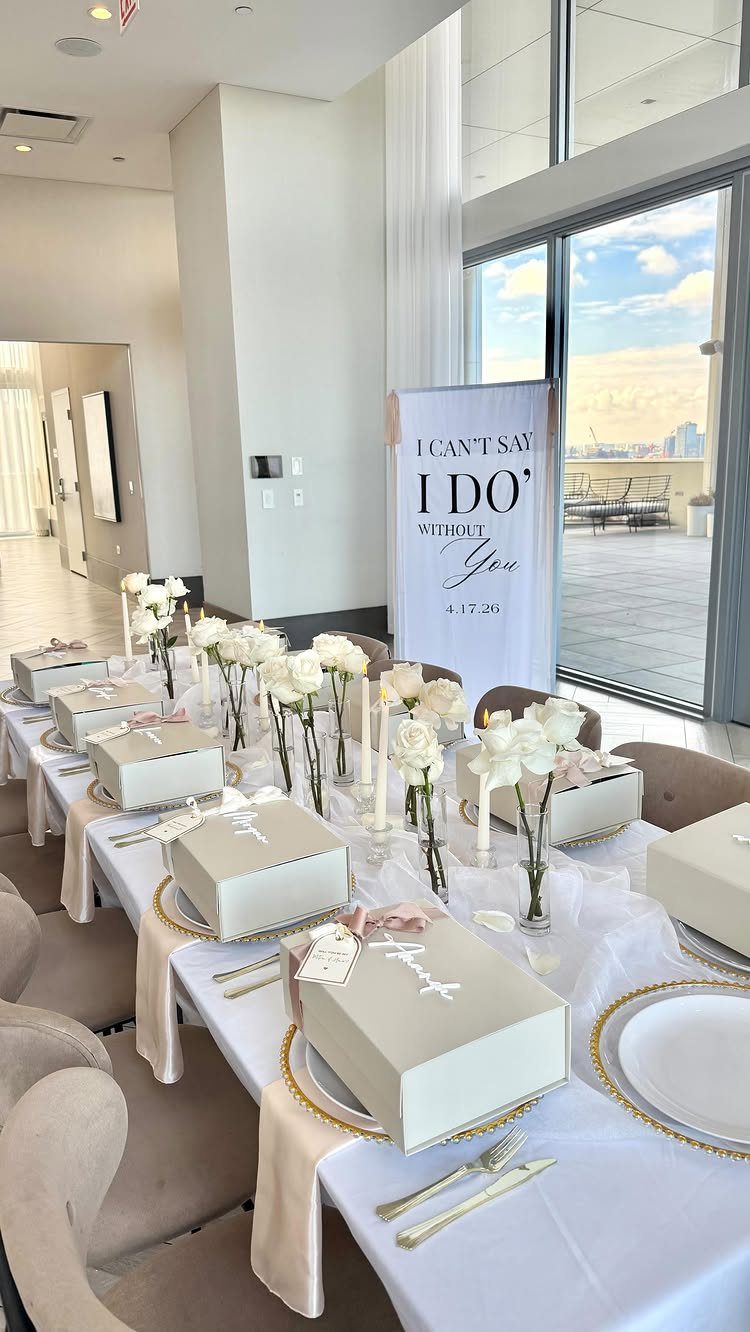 Elegant table setting with white roses and gift boxes for a bridesmaids luncheon.