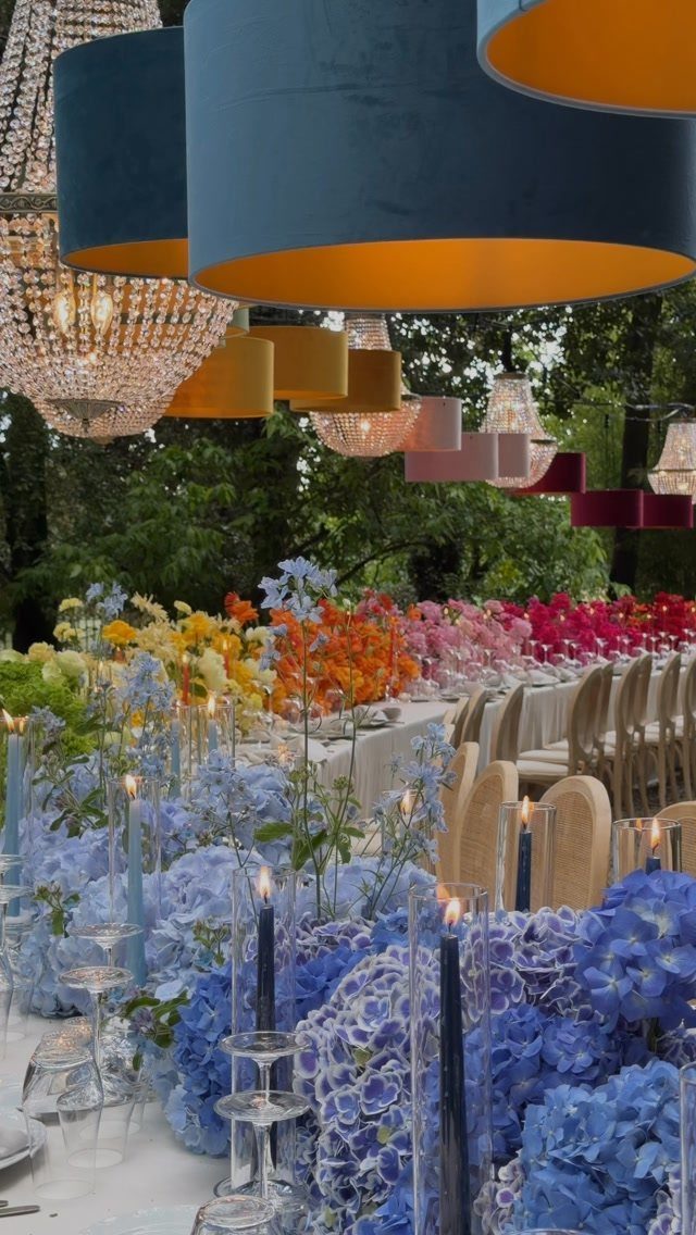 Colorful hydrangea floral arrangements and oversized hanging lampshades at a luxury wedding reception.
