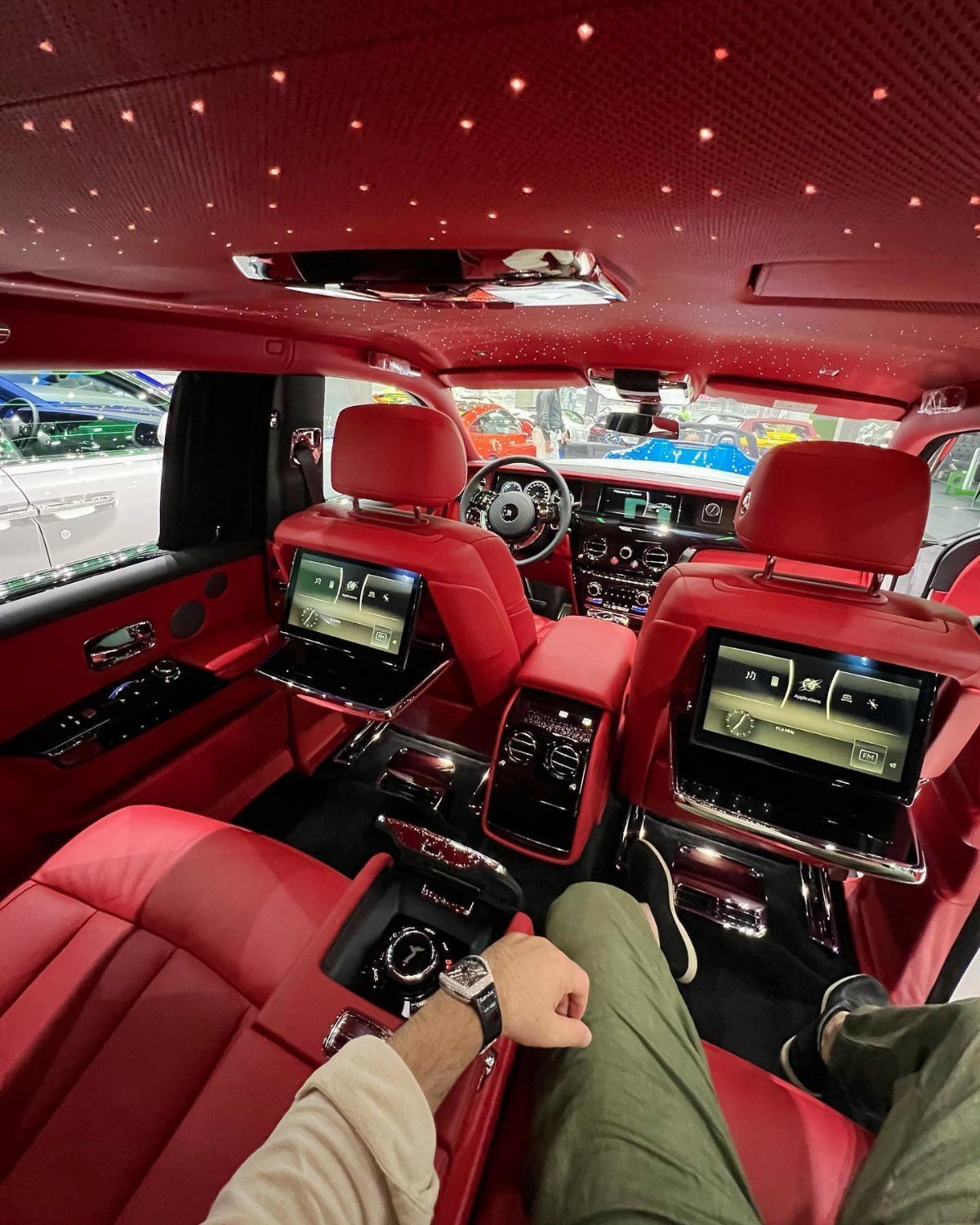 Red leather car interior with starlight ceiling and rear seat entertainment screens.