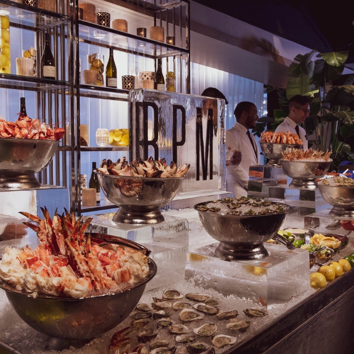 Seafood buffet with crab legs and oysters on ice at a formal event.