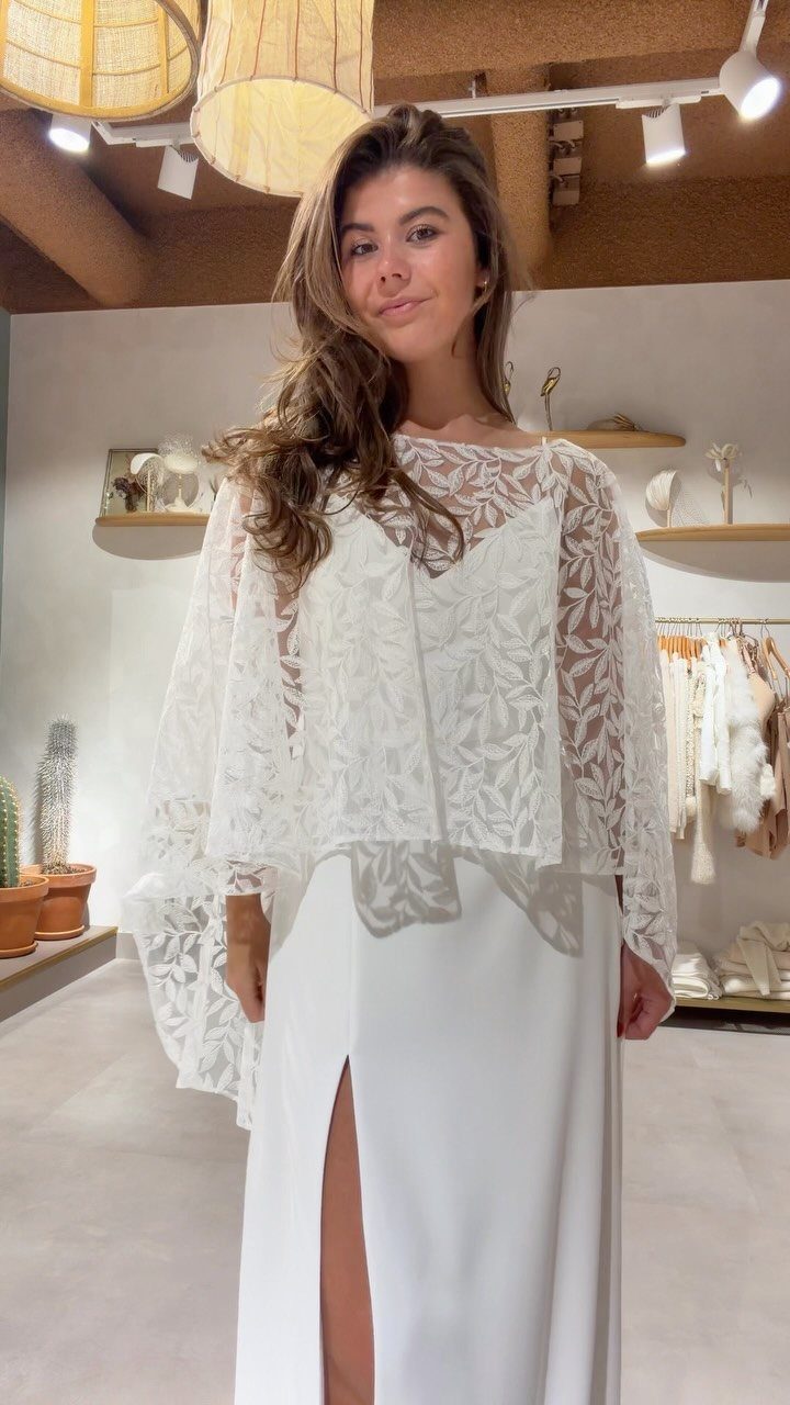 Woman wearing a white lace top and long white skirt in a boutique