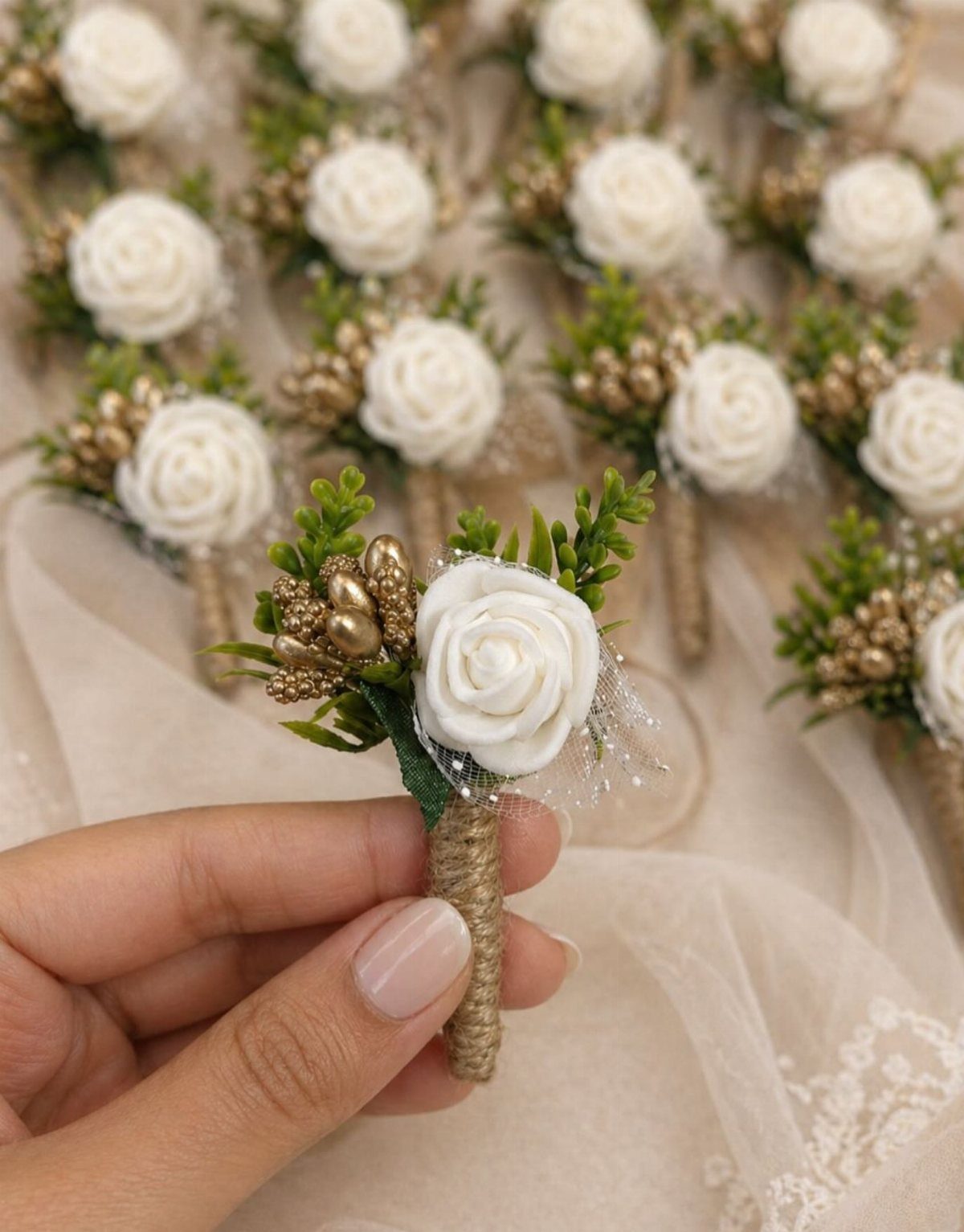 Small white rose boutonniere with gold berries held by a hand