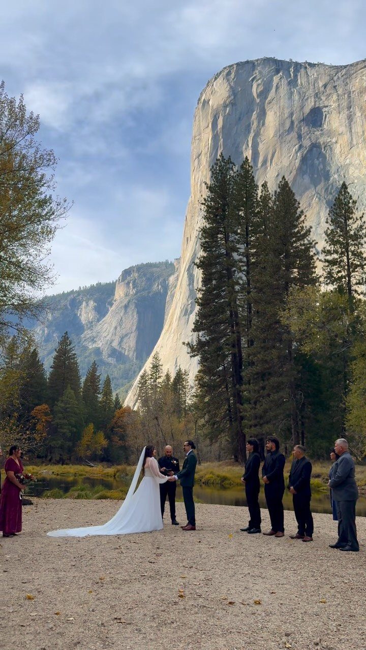 Bride and groom exchanging vows with a small group before a massive cliff