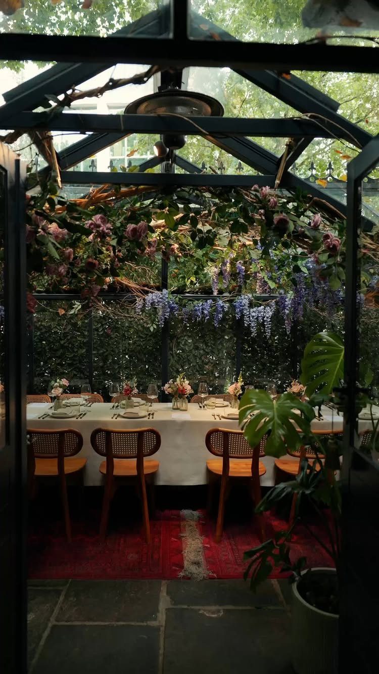 Elegant outdoor dining table set for a wedding under a floral gazebo canopy