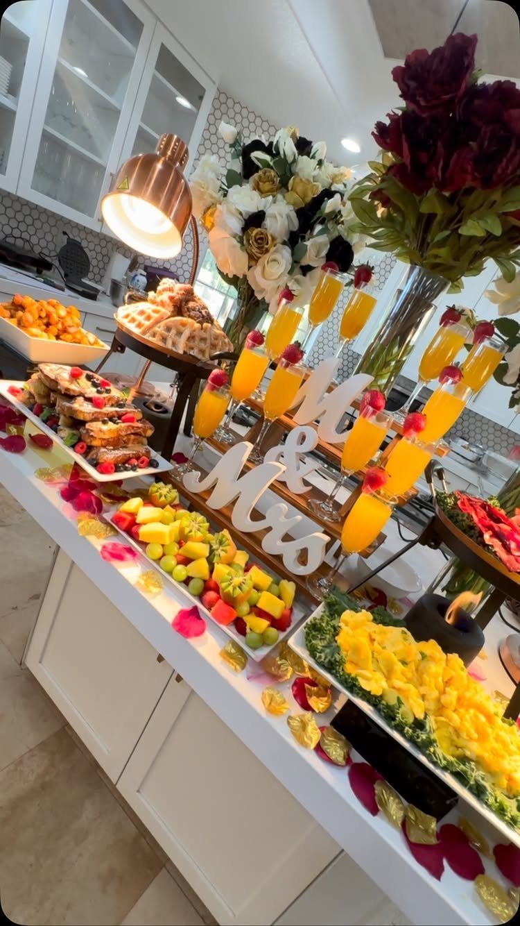 Brunch spread with waffles, mimosas, and Mr and Mrs sign on white counter.