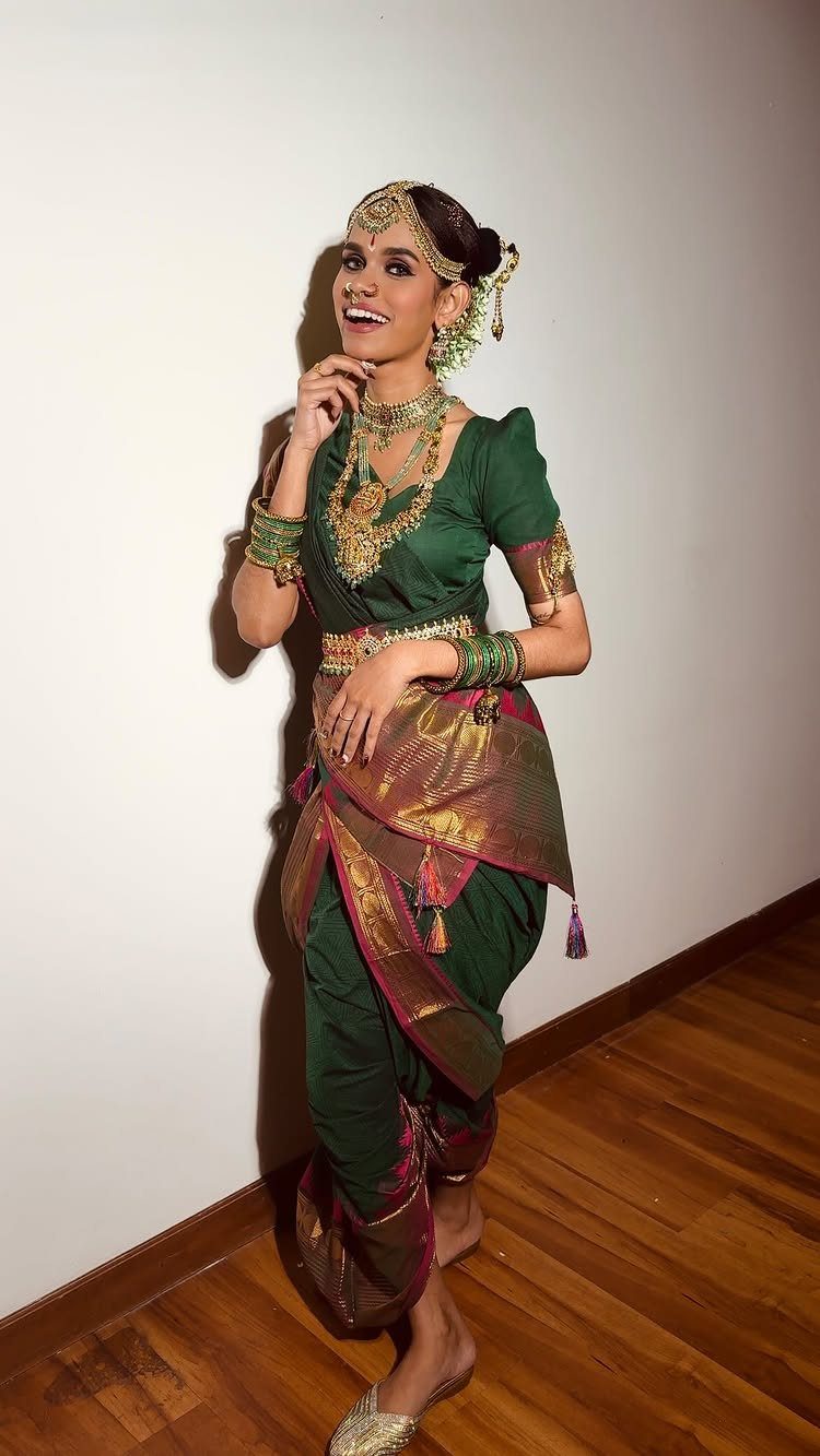 Woman in a green and gold Madisar saree with traditional gold temple jewelry.