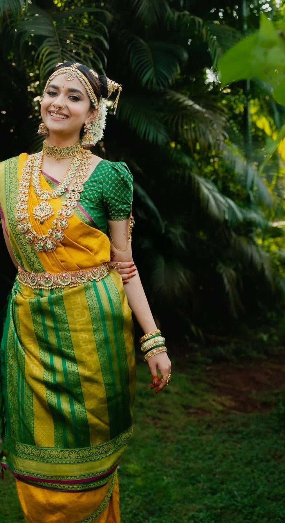 South Indian bride in yellow and green silk saree with traditional gold jewelry