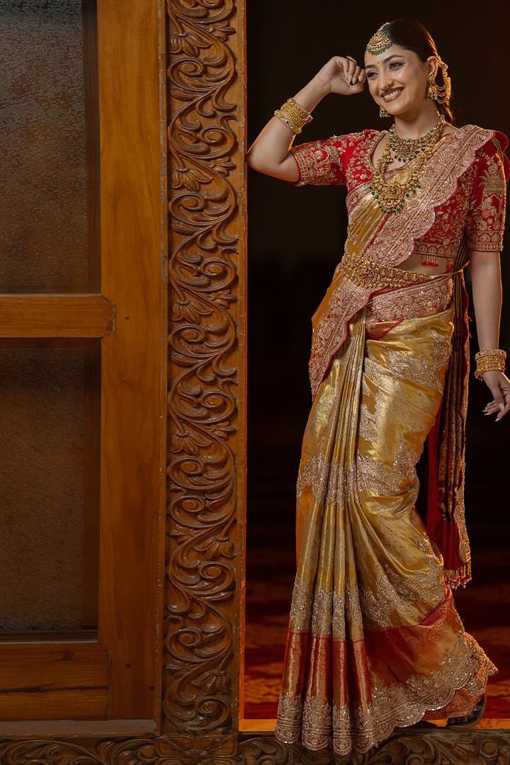 South Indian bride in gold and red zardosi saree with heavy gold jewelry
