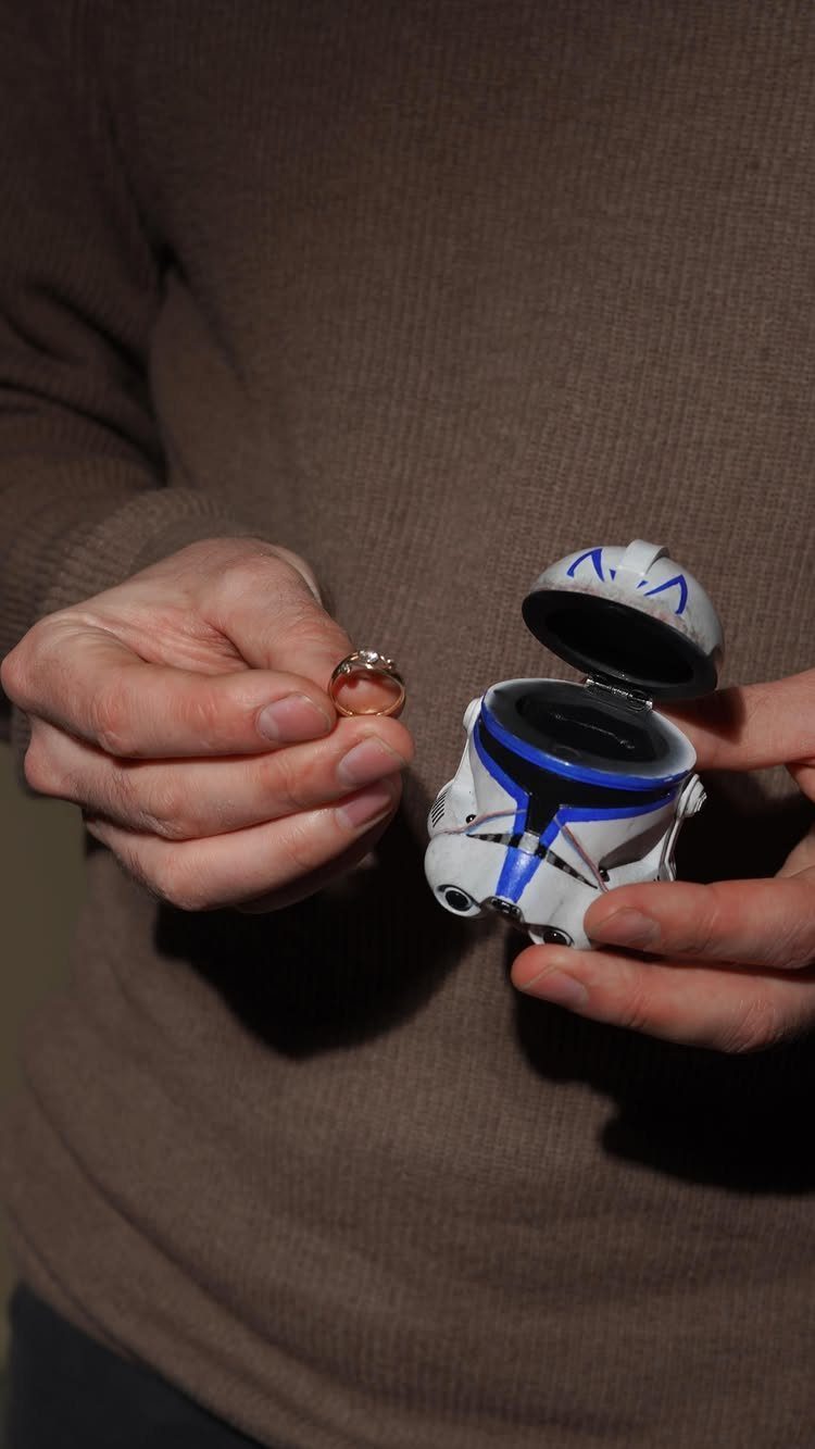 Gold ring held next to a Clone Trooper helmet ring box.