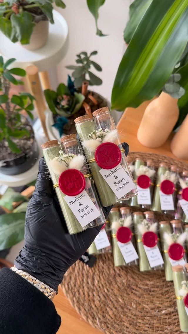 Glass vials with dried herbs, red wax seals, and name tags as wedding favors.