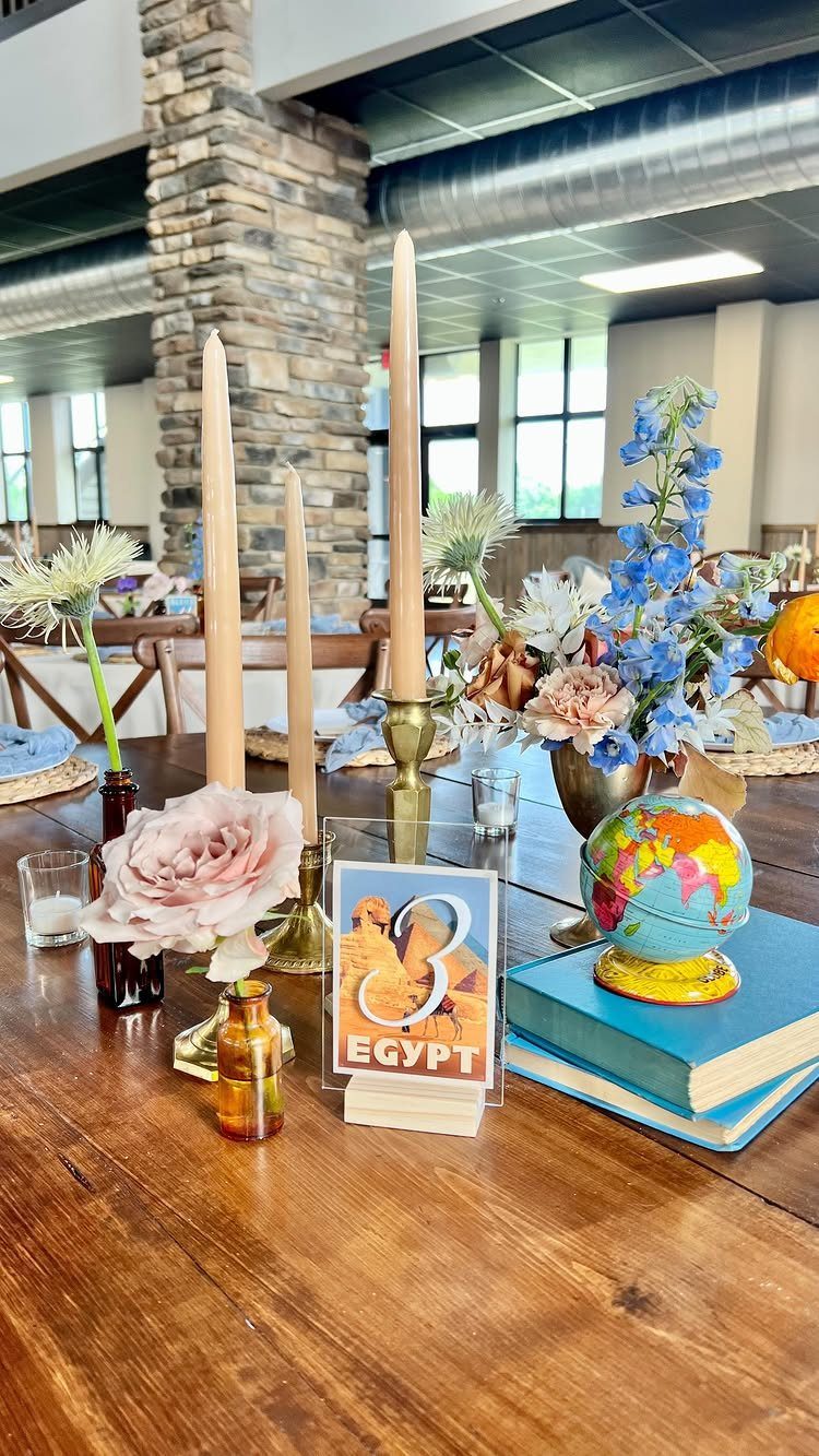 Travel themed wedding table setting with a globe, Egypt card, and taper candles.