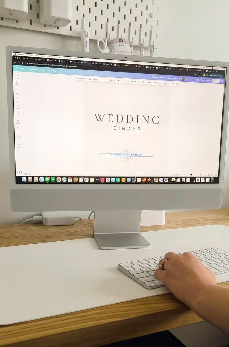 Computer monitor displaying a wedding binder digital template on a wooden desk