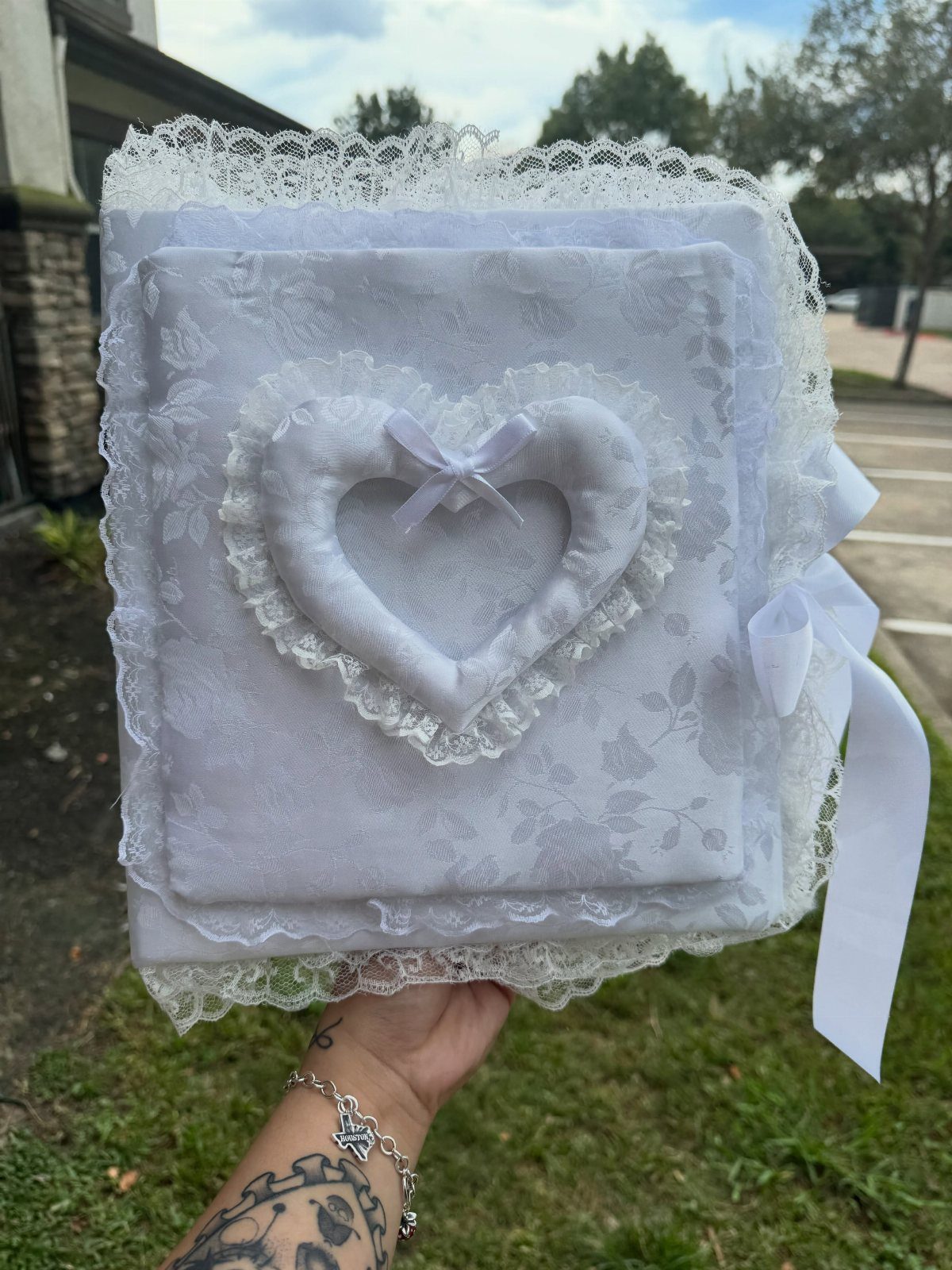 White lace wedding binder with a padded heart and satin ribbon tie.