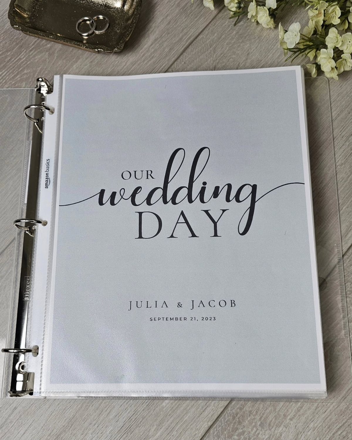 Wedding planning binder with personalized cover page on a light wooden table